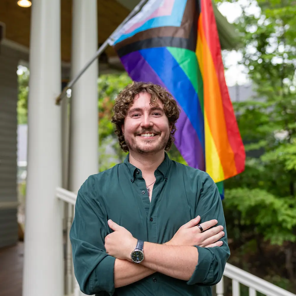 Joshua Barkes in Boise's North End in front of pride flag